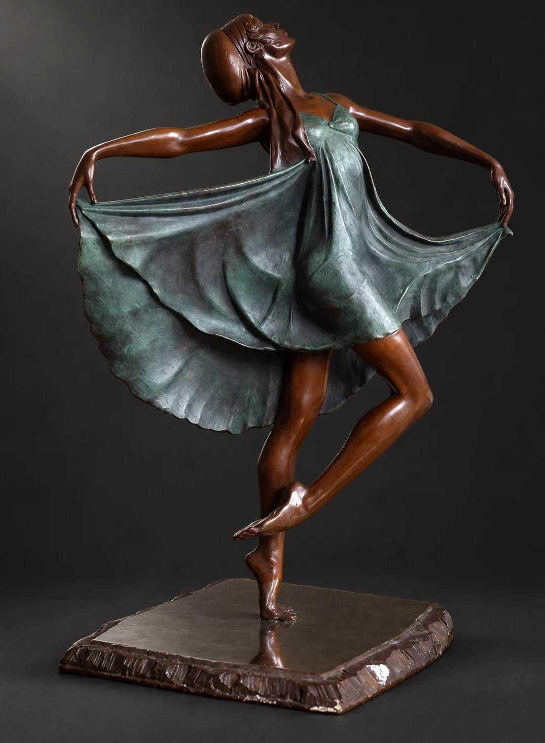 Escultura de una bailarina sosteniendo su vestido sobre una base